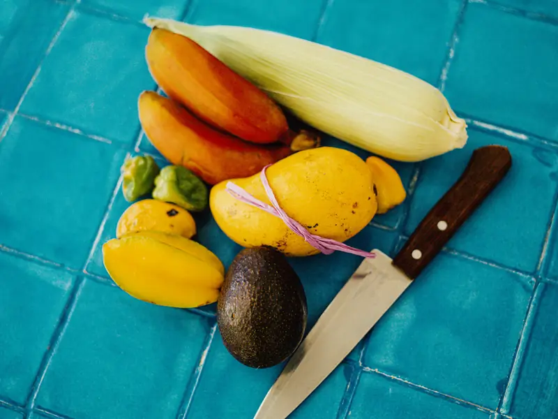 Tropical fruit and a knife on turquoise tile