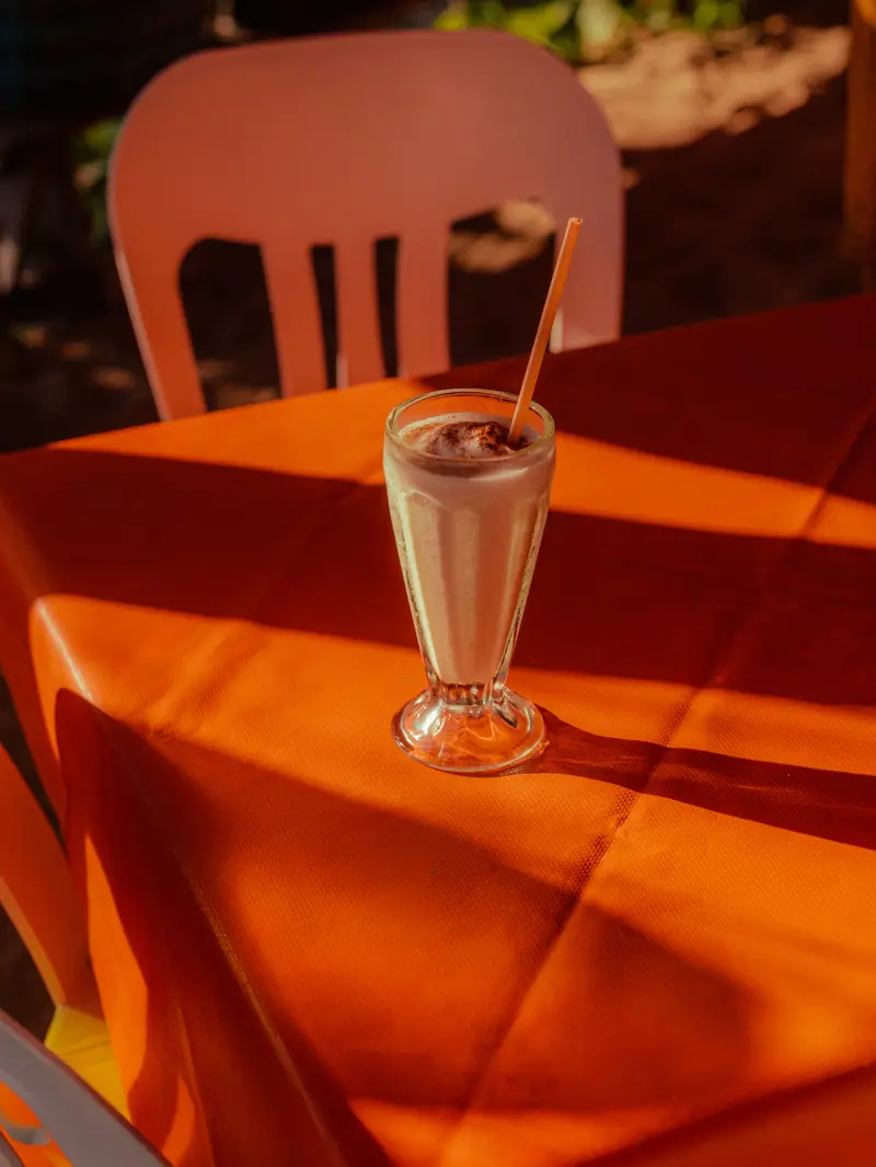 A cold drink on an orange table in hard sun